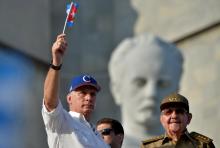 Le président cubain Miguel Diaz-Canel (g) agite un drapeau devant l'ancien président Raul Castro, lors des célébrations du 1er mai 2018 à La Havane