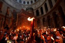 Des fidèles orthodoxes tiennent des bougies lors de la cérémonie du "feu sacré" à la veille de la Pâque orthodoxe, dans le Saint-Sépulcre à Jérusalem, le 27 avril 2019