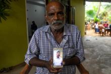 Velusami Raju, le 26 avril 2019 montre une photo de son fils Ramesh, mort en empêchant un kamikaze d'entrer dans l'église de Batticaloa, au Sri Lanka