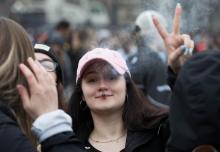 Une participante au "420" fume un joint lors du rassemblement pro-cannabis à Ottawa, le 20 avril 2019
