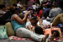 Des familles honduriennes attendent de pouvoir monter dans des bus à San Pedro Sula pour entreprendre leur voyage vers les Etats-Unis, le 9 avril 2019.