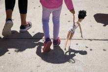 Une petite fille tient la main de sa mère, migrante clandestine, après avoir été toutes deux libérées d'un centre de rétention, le 17 juin 2018 à McAllen, au Texas
