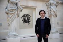 Jean-Michel Othoniel devant l'un de ses six tableaux de roses en collier de perles noires composant "La Rose du Louvre", le 24 mai 2019 dans la Cour Puget au Louvre