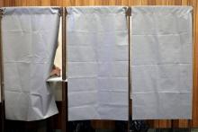 Un homme vote dans un isoloir d'un bureau de vote 