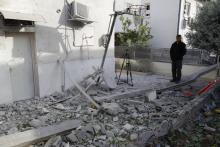 Un homme devant les débris d'un immeuble partiellement détruit par une roquette lancée depuis la bande de Gaza, à Ashkelon, en Israël, le 5 mai 2019