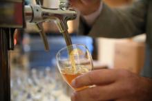 Brewers pour draft beer in an ephemeral brewery set by French brewers association 'brasseurs de France' in a winery of the Bercy district of Paris on November 9, 2017.
