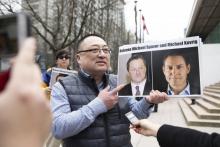 Une image des Canadiens Michael Spavor et Michael Kovrig est brandie par l'activiste de Vancouver Freedom and Democracy for China Louis Huang, le 6 mars 2019 à Vancouver
