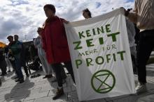 Des militants écologistes tiennent une bannière "plus de temps pour les profits" lors d'une manifestation contre le géant automobile allemand Volkswagen (VW), qui tenait son assemblée générale annuell