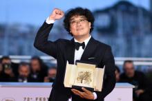 La réalisateur coréen Bong Joon-ho célèbre sa Palme d'or lors d'un photocall à Cannes, le 25 mai 2019
