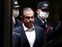 L'ancien PDG de Renault-Nissan, Carlos Ghosn, escorté par des gardiens, quitte le centre de détention après sa libération sous caution, le 25 avril 2019 à Tokyo