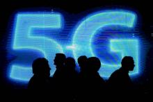 Des visiteurs devant un logo 5G lors du dernier Mobile World Congress de Barcelone, le 1er mars 2017