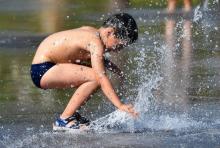 Un enfant joue dans une fontaine pendant un épisode de forte chaleur.