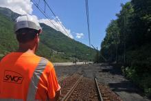 Un employé de la SNCF inspecte une section de voie ferrée recouverte par une coulée de boue due aux orages, le 3 juillet 2019 à Saint-Michel-de-Maurienne (Savoie), dans les Alpes françaises.