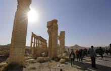 Des visiteurs se promènent dans les ruines de l'antique Palmyre en Syrie, en mai 2016