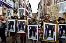 Des manifestants brandissent des portraits du président français Emmanuel Macron, décrochés dans les mairies, à Bayonne le 25 août 2019