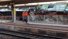 Des employés de la SNCF près d'un train qui a déraillé à Brétigny-sur-Orge, près de Paris, le 12 juillet 2013
