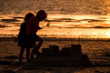 Des enfants construisent un château de sable à Gouville-sur-Mer, le 6 août 2019