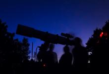 Un homme observe le ciel grâce à un télescope.