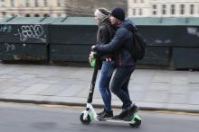 Deux jeunes circulent sur une trottinette électrique de la marque américaine Lime à Paris, le 3 mars 2019