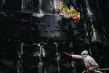 Des membres d'ATTAC pulvérisent de la peinture noire sur la façade de la tour Total à La Défense (Hauts-de-Seine), le 12 octobre 2019