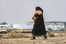 Une femme, son enfant dans les bras, dans le camp de al-Hol, au nord-est de la Syrie où se trouvent des familles de jihadistes de l'EI, le 9 décembre 2019
