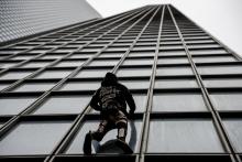Alain Robert, le "Spiderman" français, escalade à mains nues la tour Total à La Défense le 13 janvier 2020, en signe de soutien à la grève contre la réforme des retraites