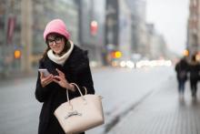 femme dans la rue regardant son téléphone
