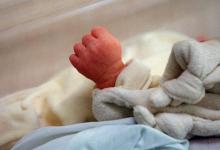 Un nouveau-né ferme son poing dans son berceau durant son sommeil, le 05 juin 2001 au service matern