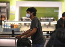 Un passager portant un masque arrive à l'aéroport de Los Angeles le 13 mars 2020
