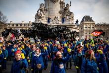 Des femmes en bleu de travail et fichu rouge manifestent contre la réforme des retraites, le 24 janvier 2020 place de la République, à Paris
