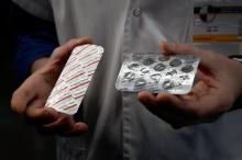 Un membre du personnel soignant de l'IHU Méditerranée Infection à Marseille montre deux plaquettes de médicaments: une de Nivaquine, qui contient de la chloroquine, et une de Plaqueril, qui contient d