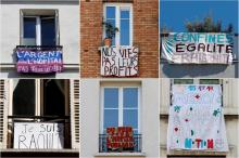Des habitants confinés en raison de l'épidémie de Covid-19 manifestent en exposant des banderoles à leurs fenêtres, le 23 avril 2020 à Paris