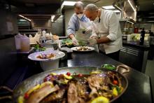 Les chefs Christian Le Squer et Alan Taudon préparent un repas pascal pour les soignants dans les cuisines de l'hôtel George V à Paris, le 11 avril 2020