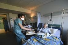 François Gérard, un plâtrier, reconverti en agent hospitalier le temps de l'épidémie de conavirus, remet un repas à une patiente à la Clinique Sainte-Anne de Strasbourg, le 14 avril 2020