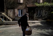 Un vieil homme rentre chez lui à Romans-Sur-Isère, le 17 avril 2020 après avoir fait ses emplettes auprès de l'épicier ambulant