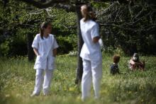 Des infirmières (dont une assise, avec le masque) et une patiente dans le jardin de l'hôpital psychiatrique marseillais de Valvert, le 16 avril 2020