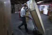 An employee of France's biggest coffin-maker, OGF group pushes a coffin in a storage room in Jussey, eastern France, on April 8, 2020, amid the spread of the COVID-19, the disease caused by the novel 