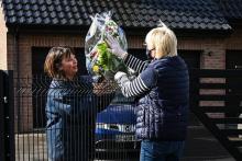 Une fleuriste livre un bouquet de fleurs et de muguet à une cliente, le 30 avril 2020 à La Couture, dans le Pas-de-Calais
