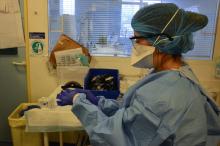 Sarah Daghsen, une infirmière spécialisée de l'hôpital Bichat AP-HP, met une combinaison de protection au rebut après avoir prodigué des soins à une patiente testée positive au nouveau coronavirus, le