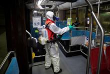 Un salarié d'une entreprise de nettoyage désinfecte un bus de la RATP, à Paris le 5 mai 2020