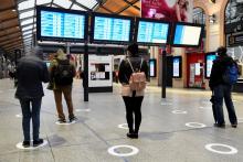 Des passagers à la gare Saint-Lazare à Paris, le 11 mai 2020 respectent les marquages au sol de distanciation sociale