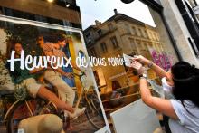 Une commerçante installe un message de bienvenue pour la clientèle, le 11 mai 2020 dans une boutique à Bordeaux