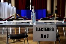 Du gel hydroalcoolique sur une table d'émargement dans un bureau de vote à Paris, le 13 mars 2020, deux jours avant le premier tour des municipales