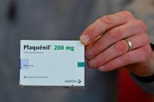 Un pharmacien montre une boîte de "Plaquénil", nom commercial de l'hydroxychloroquine, un des possibles traitements du Covid-19, le 23 mars à Rennes