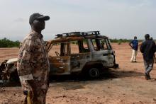 Un soldat nigérien près du véhicule où six humanitaires français et deux Nigériens ont été tués, le 21 août 2020 à Kouré, au Niger