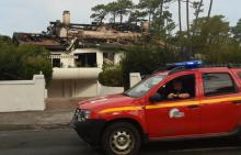 Des pompiers surveillent une maison détruite dans l'incendie de la forêt de Chiberta, le 31 juillet 2020 à Anglet, dans les Pyrénées-Atlantiques