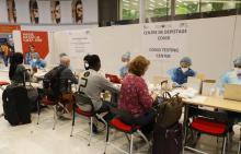 Des personnels de santé aident des voyageurs à remplir un questionnaire pour un test au coronavirus à leur arrivée à l'aéroport de Roissy-Charles-de-Gaulle, le 24 juillet 2020