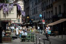 Des clients prennent un verre sur la terrasse d'un café rue de Buci à Paris le 2 juin 2020