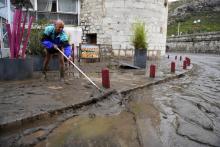 Un homme nettoie la boue sur un trottoir à Anduze, le 19 septembre 2020