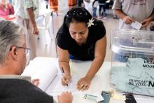 Une femme vote dans un bureau à Nouméa le 4 octobre 2020